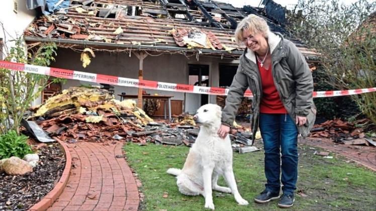 Andrea Hönerloh mit ihrer Hündin Feely vor dem zerstörten Garagentrakt des Hauses. 