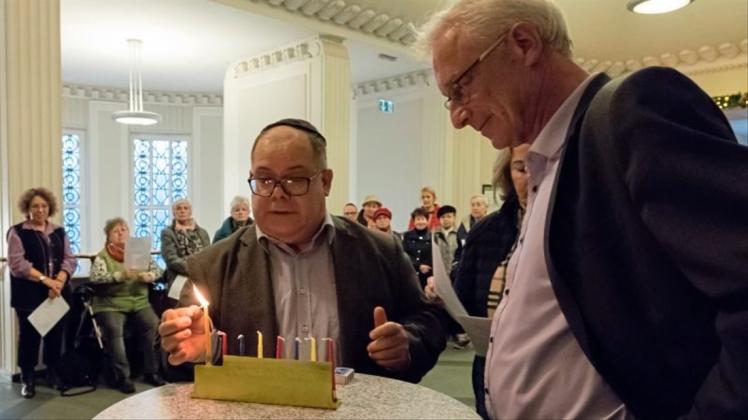 Pedro Benjamin Becerra entzündet die erste Kerze, Oberbürgermeister Axel Jahnz schaut zu. 
