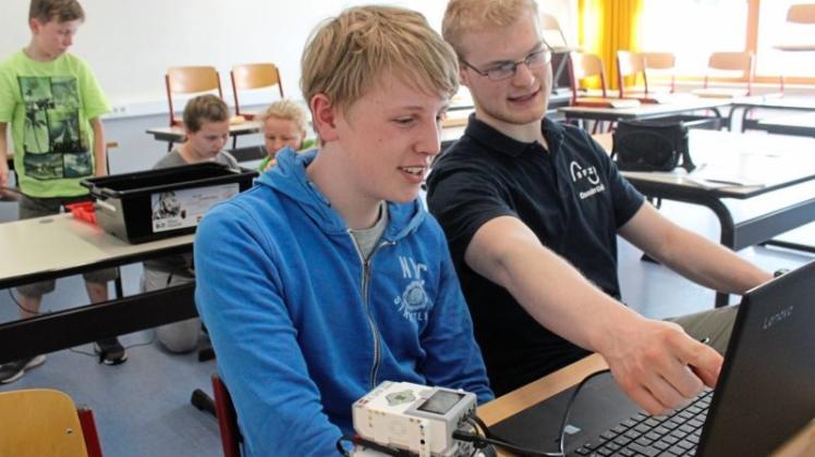 Kurze Roboter-Besprechung unter Menschen: Mattis (14) und Tutor Lukas Freudenberg; im Hintergrund werkeln Peer, Pia und SFZ-Mitarbeiterin Danuta Prasse. 