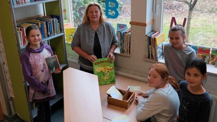 Um die Bücherausleihe in der Grundschule Walchum kümmern sich (von links) Hannah Hartelt, Maresa Eiken, Maike Specker und Noelle Bloem – sehr zur Freude von Schulleiterin Anette Slawik. 