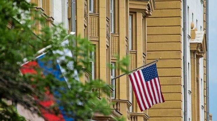Die Nationalflaggen von Russland (l) und den USA vor der US-Botschaft in Moskau (Russland). Nach dem Beschluss neuer Sanktionen gegen Moskau durch den US-Kongress müssen die USA ihr diplomatisches Personal in Russland reduzieren. 
