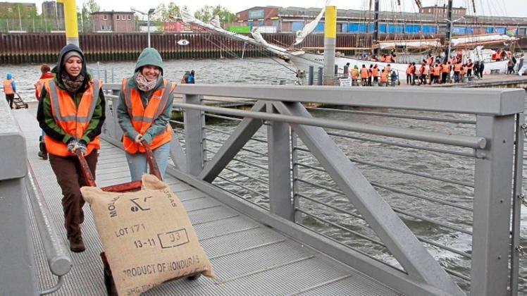 Einsatz am Europahafen – mit Sackkarren entluden mehrere Dutzend Freiwillige die 69 Kilogramm schweren Säcke und schleppten sie auf Lastenräder, die die Bio-Bohnen letztlich ins Kaffeelager transportierten. 