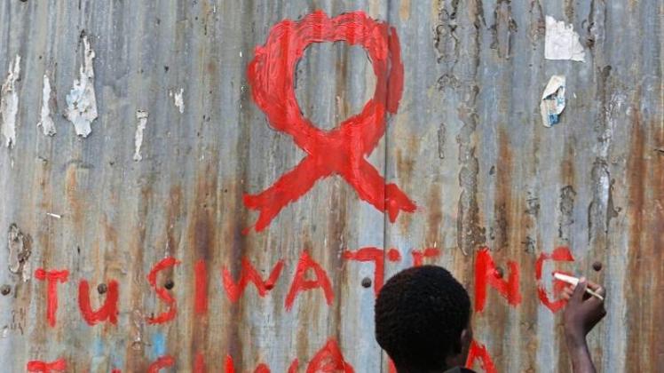 Ein junger Mann malt eine rote Aids-Schleife auf eine Wand im Kibera-Slum in Nairobi. 