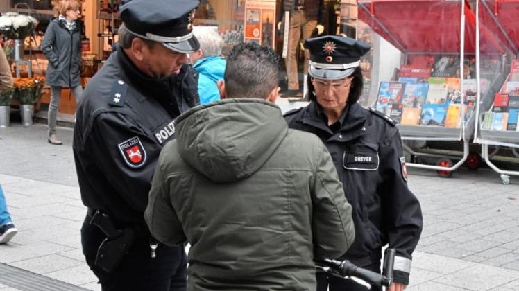 Die Polizeibeamten Torsten Blume und Ute Dreyer setzen sich in der Fußgängerzone mit einem Radfahrer auseinander. 