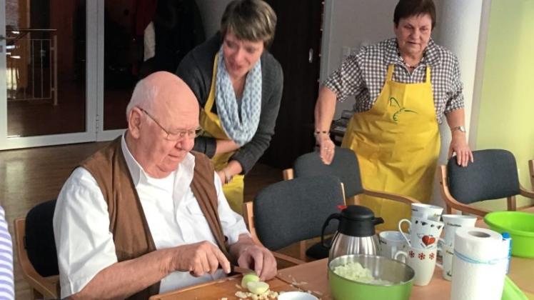 Gesundes Essen: Senioren schnipseln Zwiebeln für den Grünkohl nach Rezept von Landfrauen. 