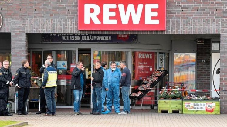 Polizei und Mitarbeiter der Spurensicherung stehen am 2. November 2017 in Bremen im Stadtteil Gröpelingen vor dem Eingang des Supermarkts, in dem ein Mann erschossen wurde. 