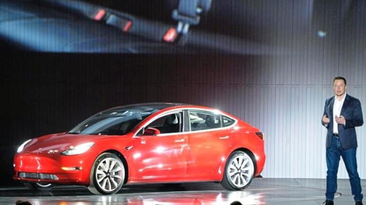 Tesla-Chef Elon Musk spricht auf dem Fabrikgelände in Fremont bei der Übergabe der ersten Wagen des Model 3. 