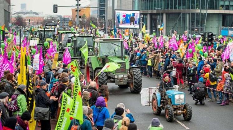 Bauern fahren am mit ihrem Traktoren im Rahmen der 7. „Wir haben es satt!“-Demonstration begleitet von einer Menschenmenge über den Potsdamer Platz in Berlin. Zuvor hatten rund 500 Landwirte vor dem Hauptbahnhof Berlin unter dem Motto „Wir machen Euch satt“
