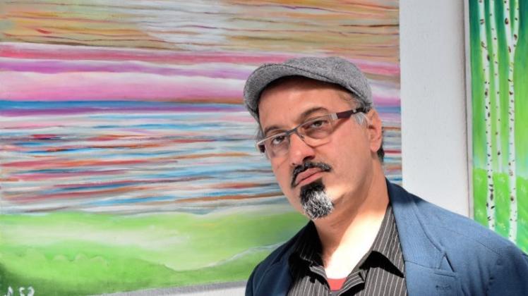 Der aus Bagdad stammende Künstler Ali Shubar, der in Ganderkesee lebt, vor einem seiner Werke, die bis 10. Oktober 2017 im Lichthof der VHS Delmenhorst zu sehen sind. 