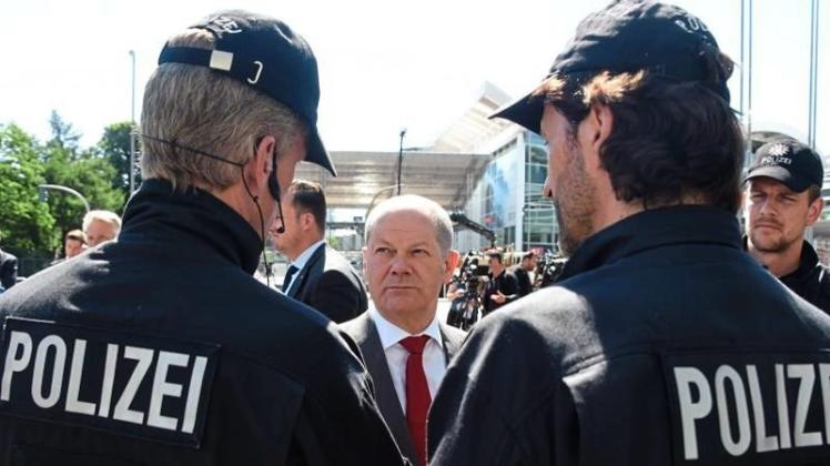 Hamburgs Erster Bürgermeister Olaf Scholz unterhält sich nach dem G20-Gipfel vor den Hamburger Messehallen mit Einsatzkräften der Polizei. 