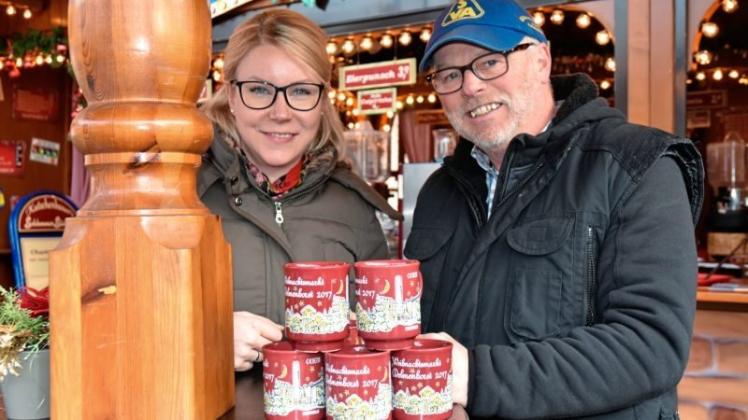 Ines Menke (Delmenhorster Wirtschaftsförderungsgesellschaft) und Schausteller Andreas Kutschenbauer präsentieren den bordeauxroten neuen Weihnachtsmarktbecher. Ines Menke (Delmenhorster Wirtschaftsförderungsgesellschaft) und Schausteller Andreas Kutschenbauer präsentieren den bordeauxroten neuen Weihnachtsmarktbecher.