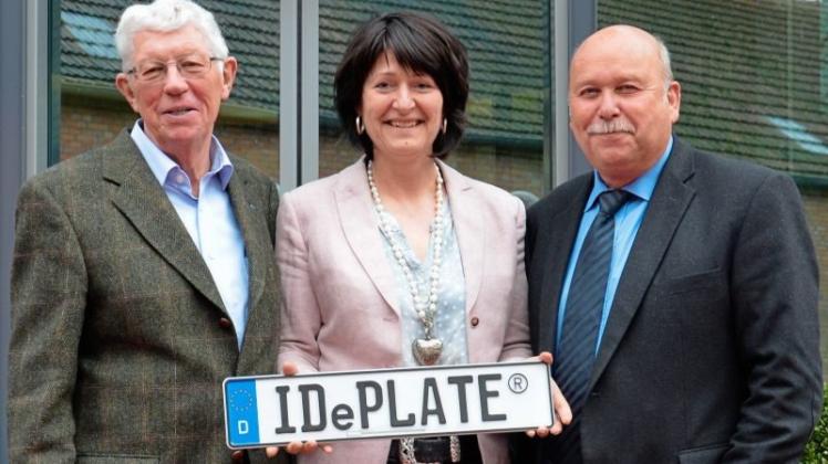 Tönnjes-Geschäftsführer Dietmar Mönning (rechts) und Bernd Tönjes aus der Unternehmensfamilie zeigen Astrid Grotelüschen (CDU) das IDePlate, das per Chip identifizierbare Autokennzeichen. 
