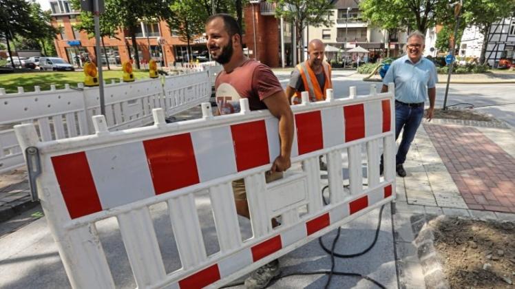 Baustelle wird abgeräumt: Bürgermeister Peter Gausmann (rechts) freut sich, dass die Dieckmann-Mitarbeiter Avdija Ahmet (Mitte) und Hasani Shpend (links) im Zentrum bei den letzten Arbeiten sind. 