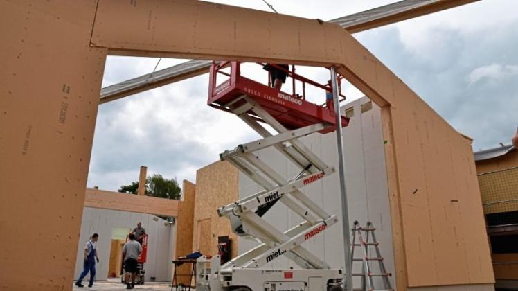 Aus großen Holzbauteilen errichten Mitarbeiter der Firma Terhalle aus Ahaus die neue Kindertagesstätte hinter der Käthe-Kollwitzschule im Rekordtempo. Gerade schwebt eine 17 Meter lange Dachpfette ein. 
