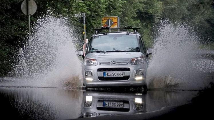 Ein Auto fährt über eine überschwemmte Straße in Hannover. Die Hochwasserlage in Niedersachsen entspannt sich allmählich. Doch es drohen neue Niederschläge. 