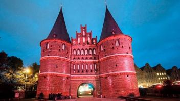 Das Holstentor in Lübeck leuchtet in der Farbe Pink. 
