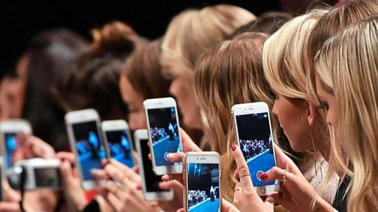 Frauen mit Smartphones filmen und fotografieren auf der Berliner Fashion Week. Die Nachfrage nach den Geräten ist auf Rekordniveau. 
