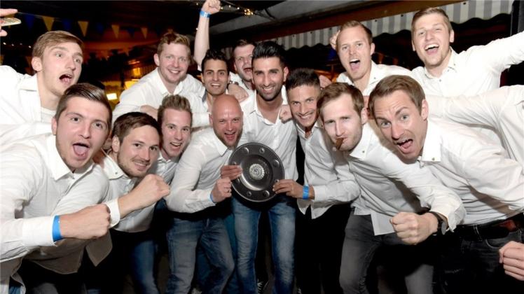 Da ist das Ding: Im Gasthof Menkens in Hoykenkamp feierte der SV Atlas die Bezirksliga-Meisterschaft. 