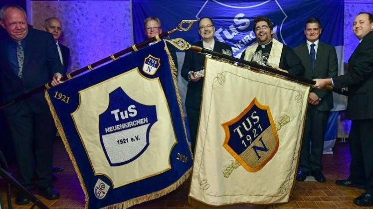 Die neue Fahne des TuS Neuenkirchen und das alte Banner (r.) nebeneinander auf der Bühne im Saal Otte. 