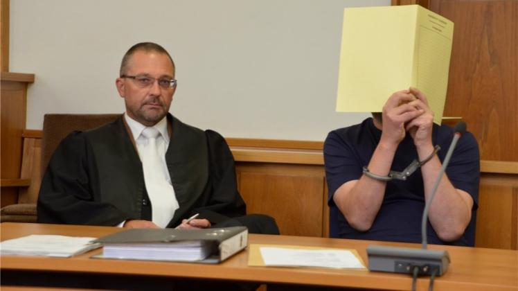 Der Delmenhorster Rechtsanwalt Axel Heinken (links) mit dem geständigen 48-Jährigen, der sein Gesicht im Gericht hinter Akten verbarg. 