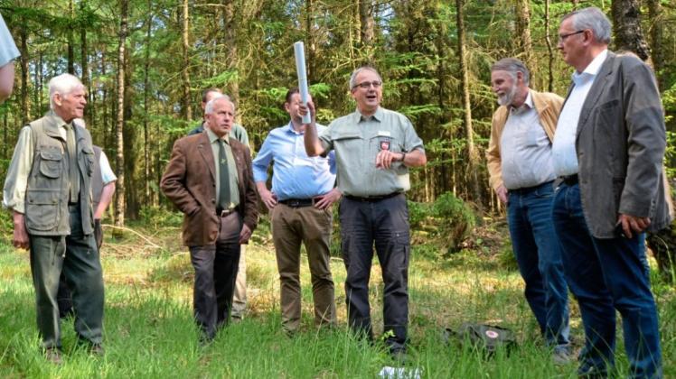 Das Land Niedersachsen möchte die Waldbesitzer im Kreis Oldenburg zum Anbau von mehr Laubholz bewegen. Diese aber fürchten schwindende Profite. Förster Michael Feiner (Bildmitte) erklärt Waldbesitzern die Beschaffenheit des Bodens in einem Forst bei Großenkneten. 