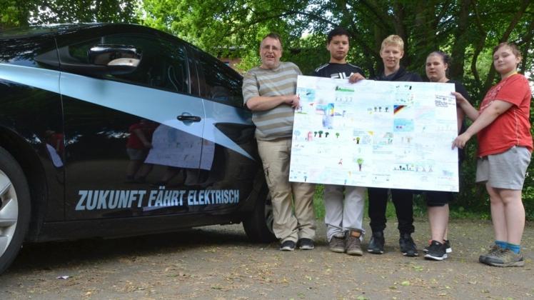 Klimaschutz-Pilot und Renault-Zoe-Fahrer Roland Klose (links) erhält vom Energieteam der Schule am Habbrügger Weg die Klimaschutzversprechen von 64 Förderschülern mit auf den Weg der „Wave“. Die Tour führt von Bremerhaven bis in die Schweiz. 