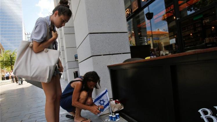 Ein neuer Anschlag in Tel Aviv hat nach Wochen relativer Ruhe das Gefühl vermeintlicher Sicherheit zerstört. Hier legen zwei Frauen Blumen am Ort des Anschlags nieder. Ein neuer Anschlag in Tel Aviv hat nach Wochen relativer Ruhe das Gefühl vermeintlicher Sicherheit zerstört. Hier legen zwei Frauen Blumen am Ort des Anschlags nieder.