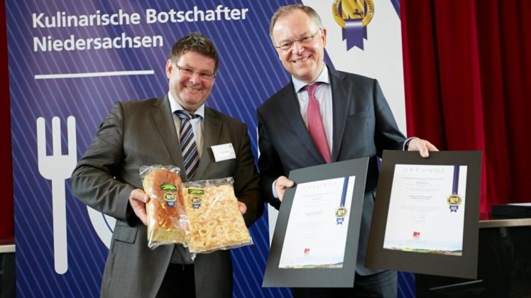 Zwei Urkunden übergab Ministerpräsident Stephan Weil an Axel Tönjes (links). Der Butterkuchen und die Kürbisstuten wurden zu „kulinarischen Botschaftern Niedersachens“ auserkoren. 