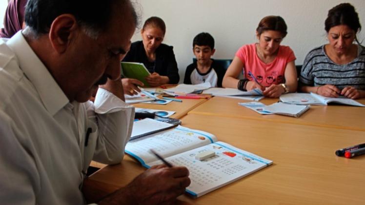 Pauken vor dem Spracherwerb: Flüchtlinge in Düsternort lernen im Nachbarschaftsbüro der Diakonie das Alphabet. 