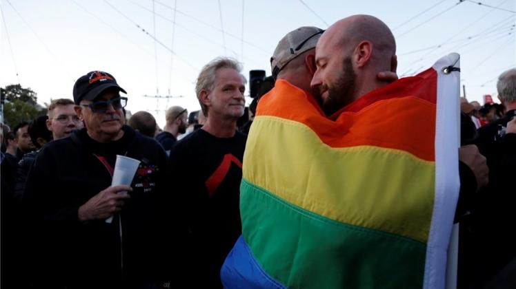 Der Schock sitzt tief in Amerika: Ein schwules Pärchen umarmt sich in Florida mit einer Regenbogenflagge. Der Schock sitzt tief in Amerika: Ein schwules Pärchen umarmt sich in Florida mit einer Regenbogenflagge.