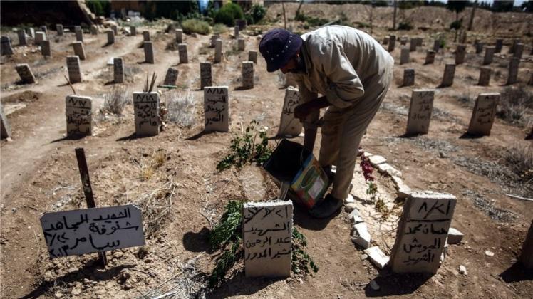 Qualvoller Tod: Ein Friedhofsmitarbeiter in Douma nahe Damaskus pflegt das Grab eines jungen Mannes, der bei einem Chemiewaffen-Angriff starb. Ein neuer UN-Bericht listet allein neun Giftgas-Einsätze in Syrien auf. 
