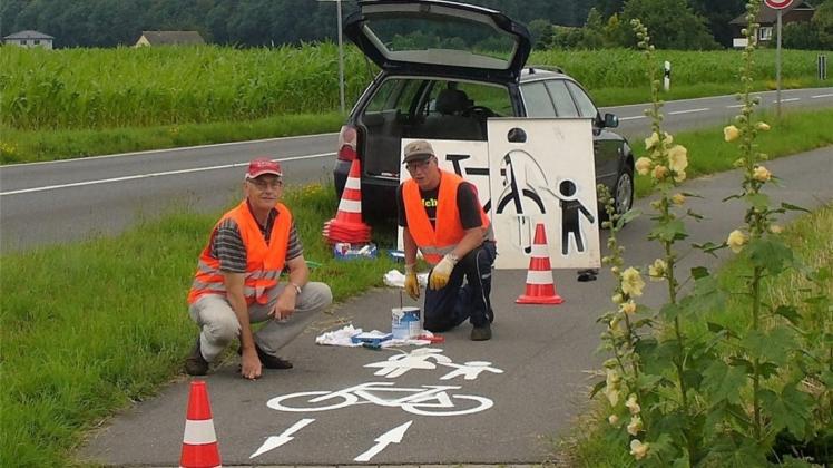 Das erste Piktogramm tragen Wilhelm Melcher (links) und Wolfgang Hopp in Wersen auf dem Radweg in Richtung Halen auf. 