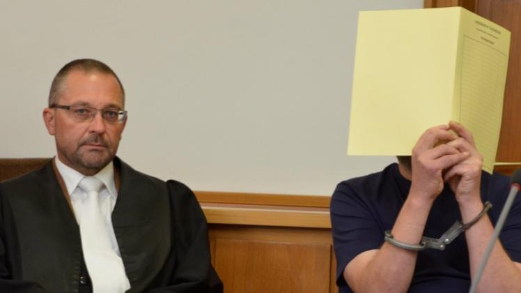 Der Delmenhorster Rechtsanwalt Axel Heinken (links) mit dem geständigen 48-Jährigen, der sein Gesicht im Gericht am ersten Prozesstag hinter Akten verbarg. 