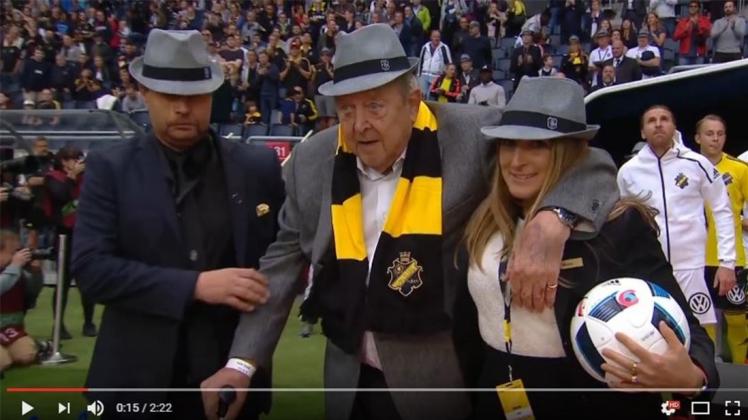 Gestützt von einer Helferin betritt der ehemalige UEFA-Präsident das Stadion des AIK als „Einlaufkind“. 