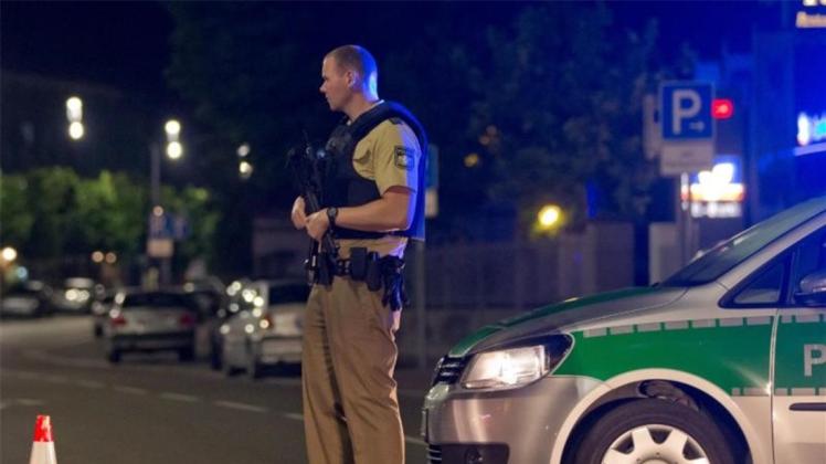 Ein schwerbewaffneter Polizist bewacht die Zufahrtsstraße zur Altstadt. 