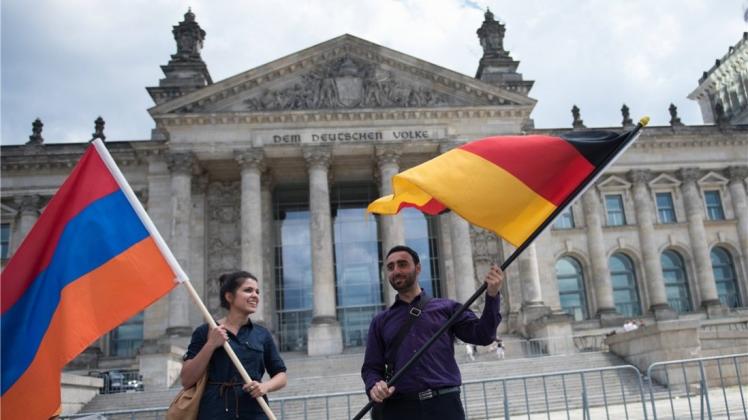 Die armenische und die deutsche Fahne schwenken Demonstranten vor dem Reichstag, nachdem in einer Resolution der Massenmord an Armeniern als Völkermord bezeichnet wurde. Foto:imago/CommonLens