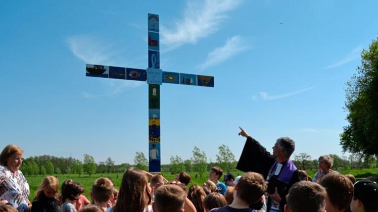Gemeinsam mit Kindern und Religionslehrerinnen der Käthe-Kollwitz-Schule hat Pastor Stephan Meyer-Schürg am Dienstagvormittag die Fertigstellung des Pilgerkreuzes im Einmündungsbereich Hoyersgraben/Heidkruger Bäke gefeiert. 