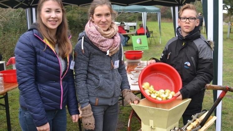 Apfeltag auf der Streuobstwiese: (von links) Vanessa Barghop, Marje Stubbemann und Eik Tielking verarbeiten Apfelschnitzel an einer Presse zu köstlichem Saft. Apfeltag auf der Streuobstwiese: (von links) Vanessa Barghop, Marje Stubbemann und Eik Tielking verarbeiten Apfelschnitzel an einer Presse zu köstlichem Saft.