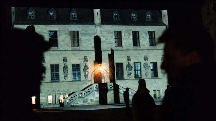 Echtzeit-Schatten von Besuchern des Marktes auf der Rathaus-Fassade. 