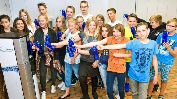 Schülerinnen und Schuler der Klasse 7B der Sophie-Scholl-Schule am Standort Kloster Oesede freuen sich über die Inbetriebnahme des Wasserspenders. Zur Eröffnung gab es Trinkwasserflaschen der Stadtwerke Georgsmarienhütte geschenkt. 