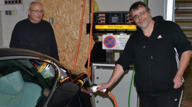 Roland Klose (rechts) hat eine klassische Tanksäule ausgewaidet und mit Schnellladetechnik für E-Mobile bestückt. Michael Ohlhorst kommt so mit seinem Tesla gut zurück nach Halstenbek-Krupunder. 
