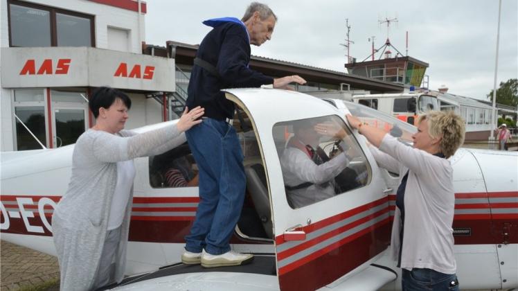 Swenja Krusche (links) und Haik Westendorf helfen Manfred Meister beim Einsteigen in das Flugzeug nach Helgoland. 