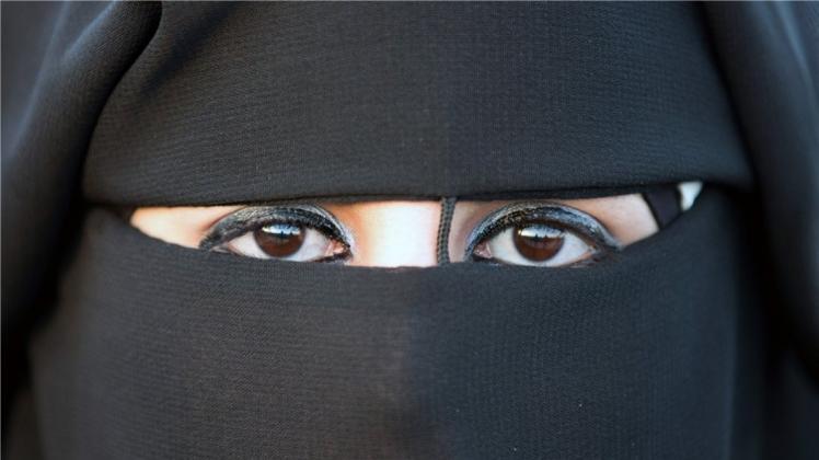 Eine Frau mit Nikab, ein Gesichtsschleier, der das Gesicht bis auf einen Sehschlitz verdeckt. 