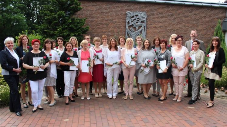 Glücklich und stolz über ihren Erfolg sind die 23 examinierten Soziallassistentinnen - Schwerpunkt Sozialpädagogik der Klasse BSA II D, die neben ihrem Beruf in den Kinderkrippen ein Jahr die Fachschule St. Franziskus besuchten, und nun ihre Zeugnisse erhielten. Die stellvertretende Schulleiterin Evelyn Stickling (links) und Schulleiter sowie Klassenlehrer Dr. Ludger Mehring freuen sich mit ihnen. Glücklich und stolz über ihren Erfolg sind die 23 examinierten Soziallassistentinnen - Schwerpunkt Sozialpädagogik der Klasse BSA II D, die neben ihrem Beruf in den Kinderkrippen ein Jahr die Fachschule St. Franziskus besuchten, und nun ihre Zeugnisse erhielten. Die stellvertretende Schulleiterin Evelyn Stickling (links) und Schulleiter sowie Klassenlehrer Dr. Ludger Mehring freuen sich mit ihnen.