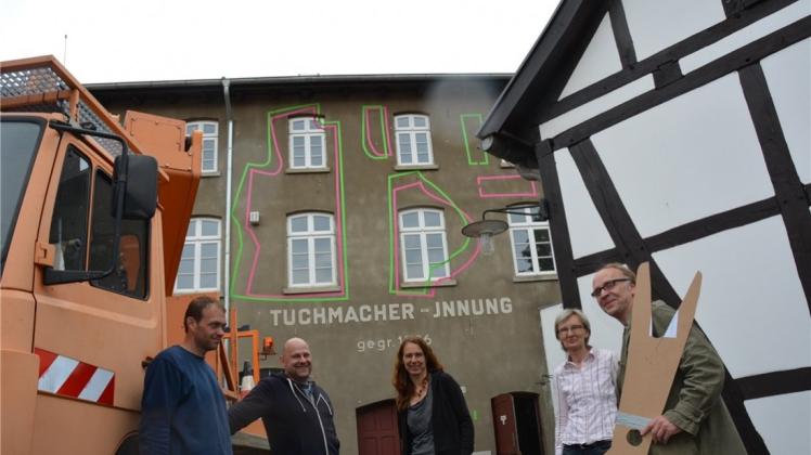 Ein Riesen-Schnittmuster ziert die Fassade des Tuchmacher-Museums. Darüber freuen sich Lars Meckfessel von der Stadtwerken, die das Projekt unterstüzen, Reiner Wolf, Kerstin Schumann, Margarethe Joseph und Bernd Rüsel.