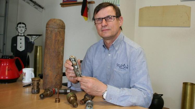Bremens Sprengmeister Andreas Rippert betrachtet einen Aufschlagszünder. Links im Bild: eine Brandbombe, einst gefüllt mit hochgefährlichem Phosphor. 
