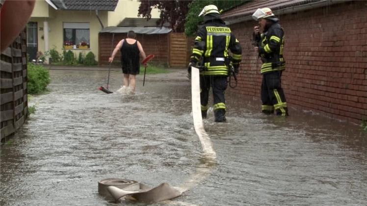 Nach kurzen heftigen Regenschauern stehen viele Straßen in Nordrhein-Westfalen unter Wasser, Feuerwehrleute und Anwohner waten durchs Wasser. Symbolfoto: NWM-TV