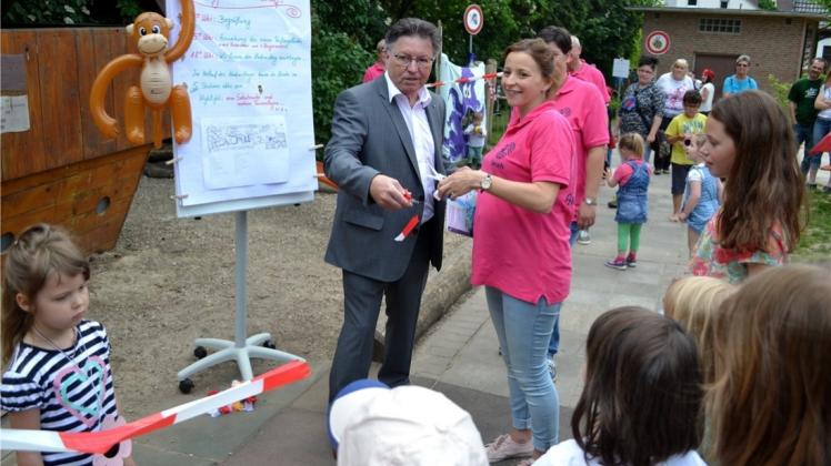 Weg mit dem Absperrband: Bürgermeister Hartmut Nümann und Fördervereinsvorsitzende Sarah Wißmann feierten die Fertigstellung des neuen Spielplatzes des Willy-Schulte-Kindergartens. 