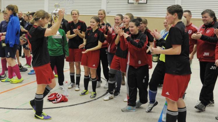 Da ist das Ding: Stenums Mannschaftsführerin Ann-Kristin Willms präsentiert ihrem Team den Siegerpokal. Fotos: Rolf Tobis