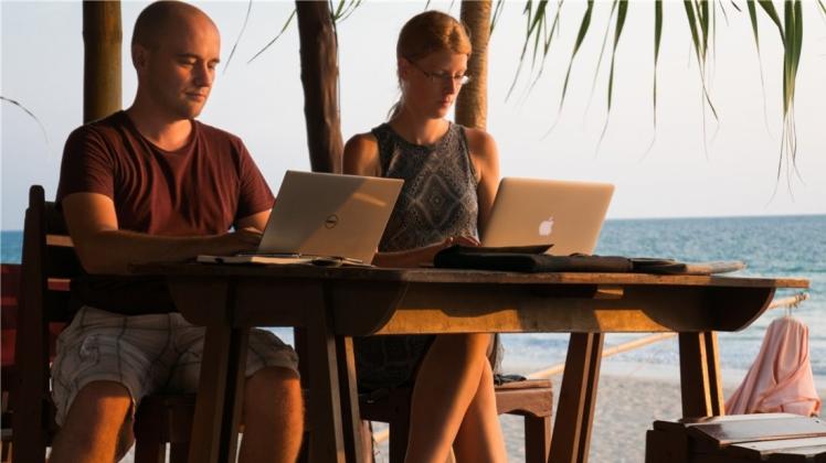 Sören Weber und Lena Meyer sind trotz Sonne, Strand und Meer vertieft in ihre Arbeit. 
